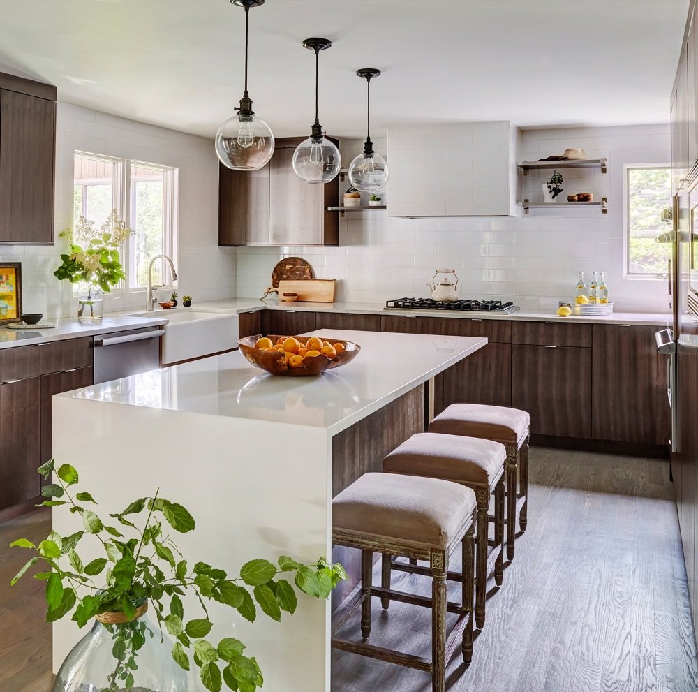 Kitchen with walnut cabinets and white waterfall island, luxury renovation and interior design by Martire Custom Homes